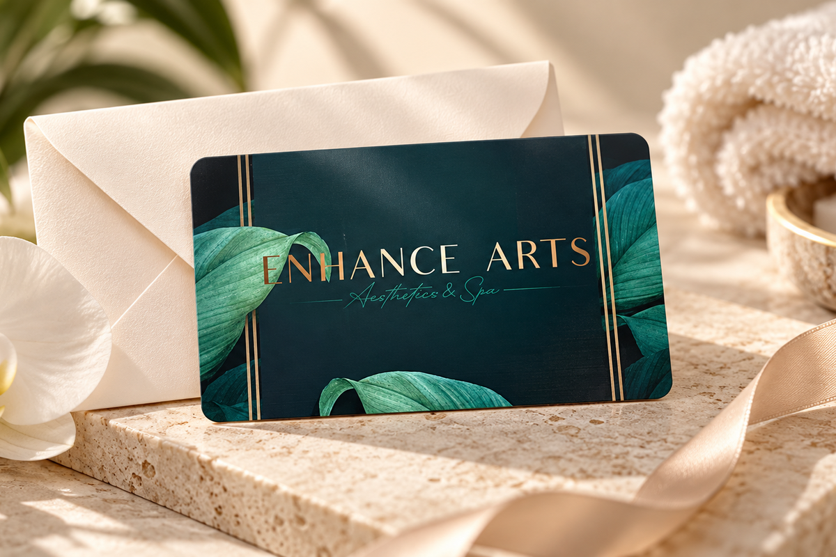 Enhance Arts Spa gift card displayed with an envelope, orchid and spa towels in Vancouver.